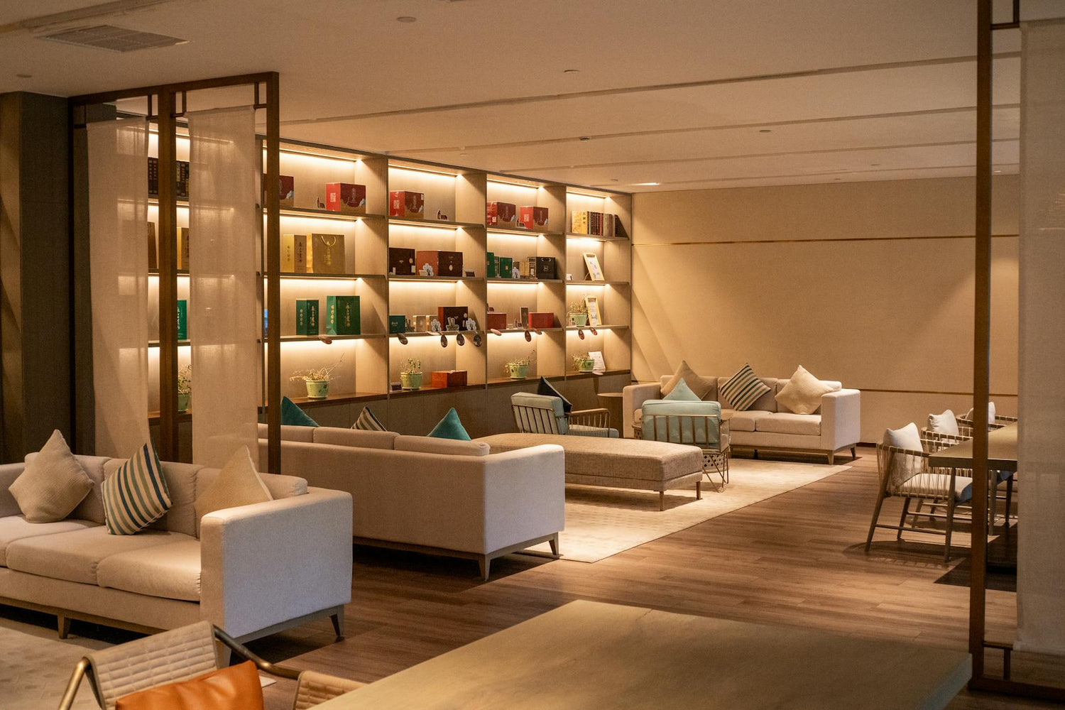 Modern hotel lounge with cozy seating and illuminated shelves in Hangzhou, China.