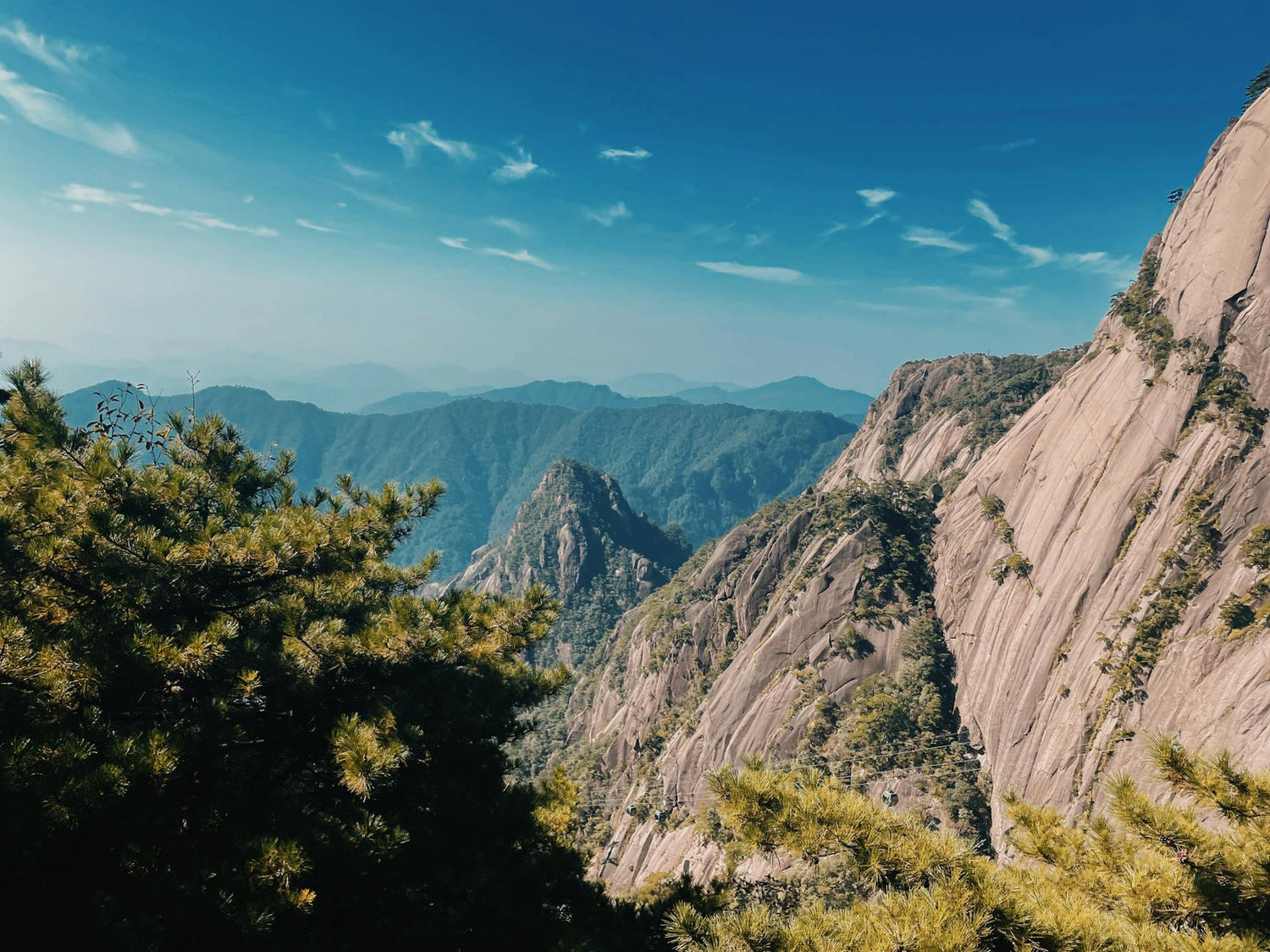 Breathtaking view of Huangshan mountain peaks under a clear blue sky.