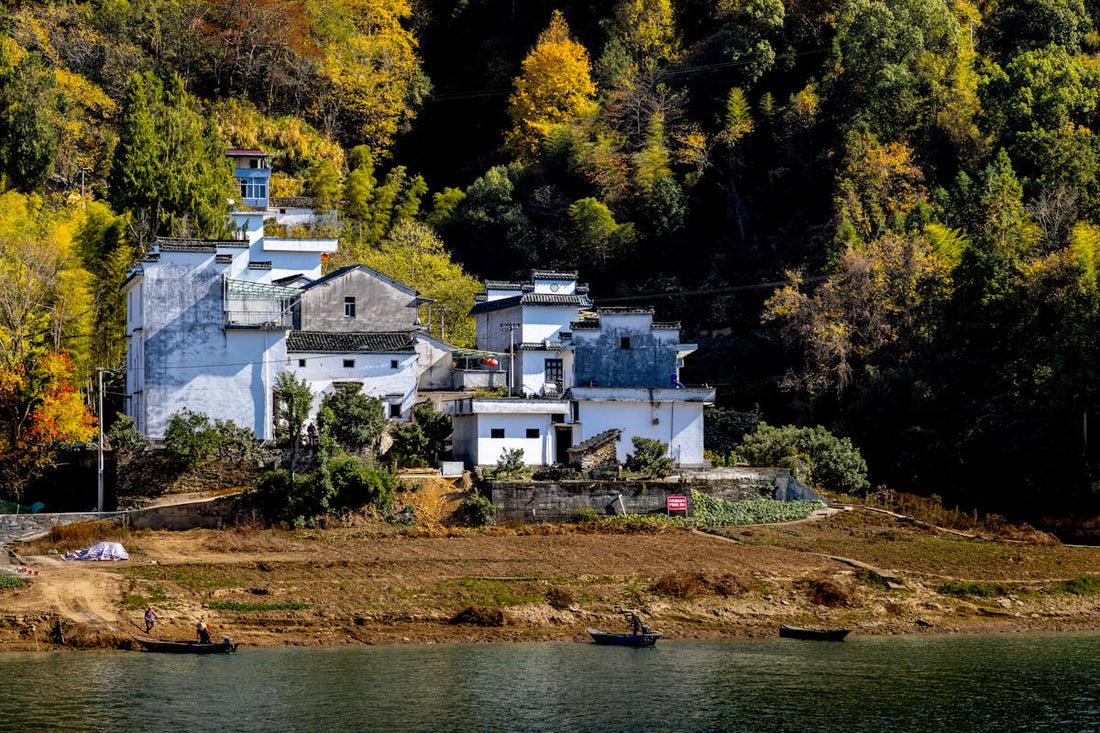 Traditional Chinese village surrounded by autumn foliage along a river - best time to visit China